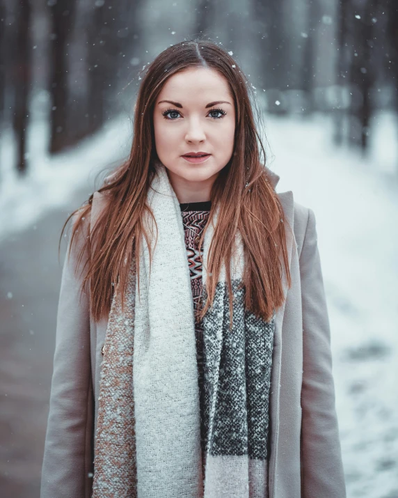 a young woman standing in the snow outside