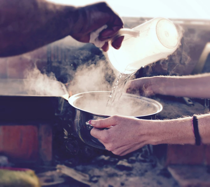 a person pouring soing out of a pot