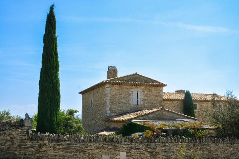 a stone and stone house near a large tree