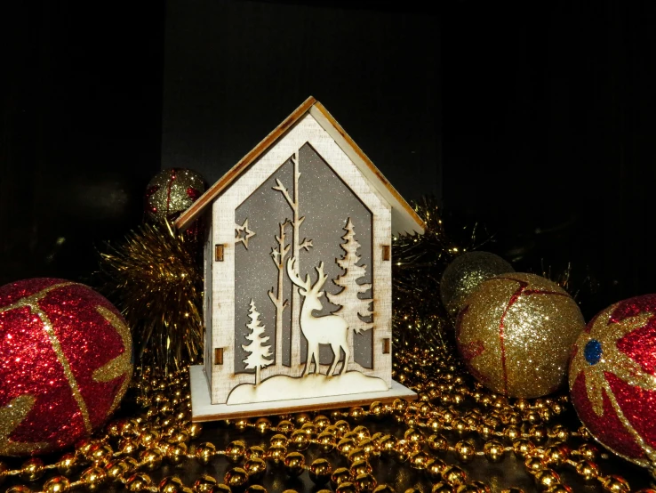 a small decorative house stands on display at christmas