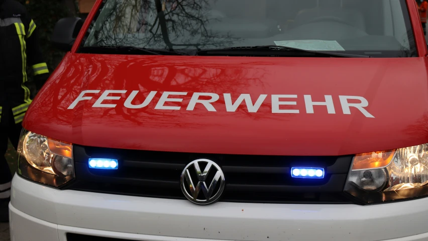 a white van with a red emblem and two blue lights