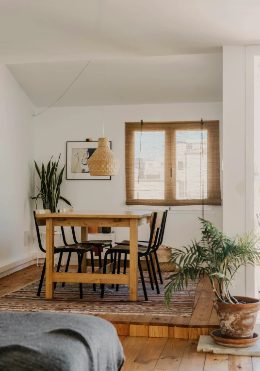 a table, couch and a potted plant are arranged in an otherwise empty room