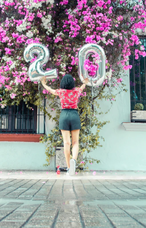 a girl with balloons is holding some numbers