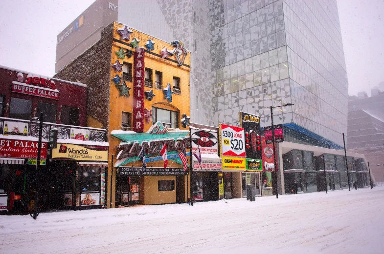 a city intersection with tall buildings covered in snow