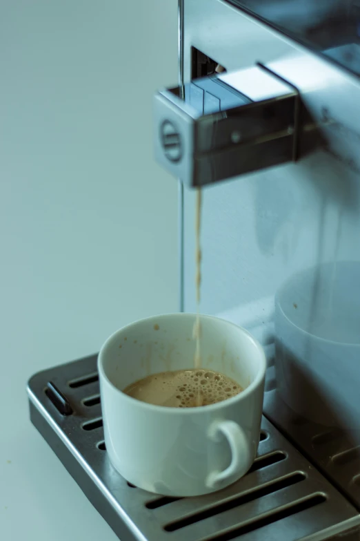 a cup of coffee is being served at an espresso machine