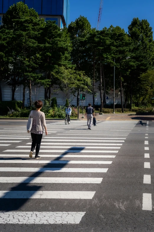 two people walk across an empty parking lot in the city