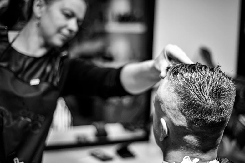 a hair  parlor worker combs another man's hair