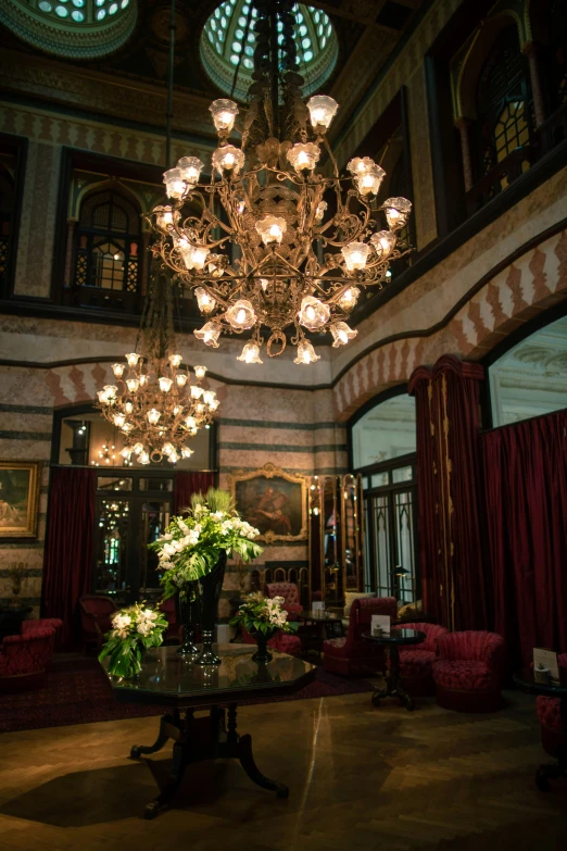 a lobby has a chandelier and red couches