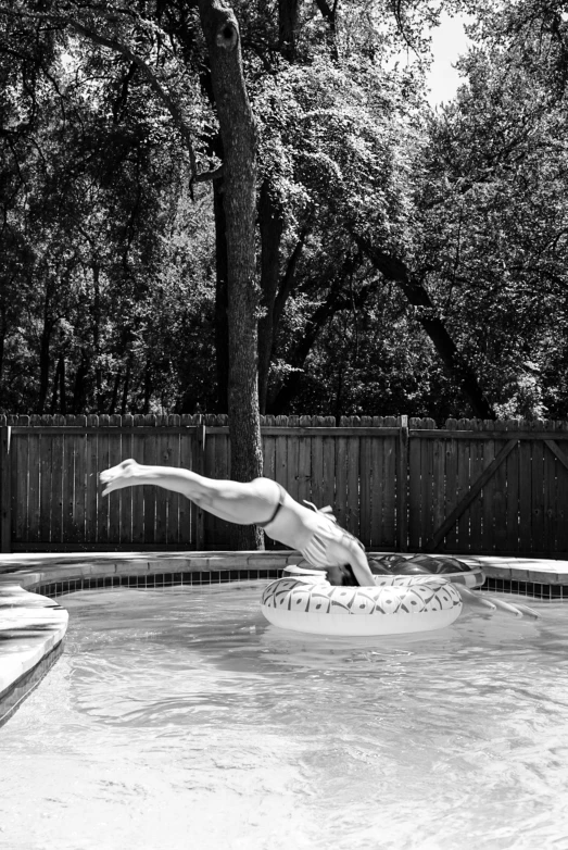 a man in the swimming pool, diving for a ball