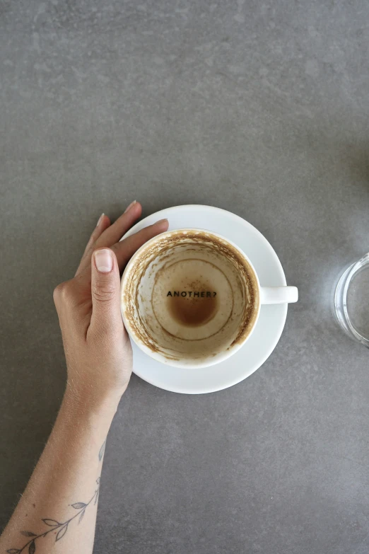 a person holds a coffee cup with their left hand