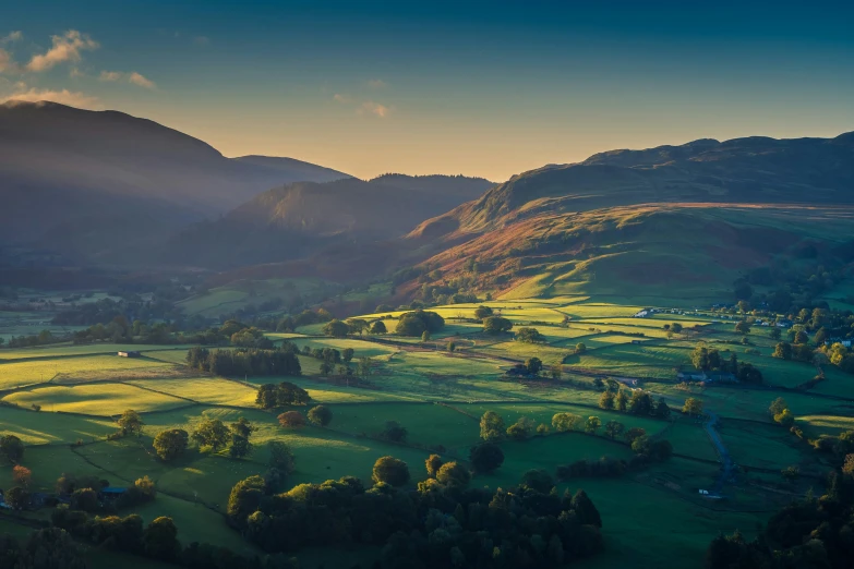 there is a scenic area with mountains, grass, and clouds