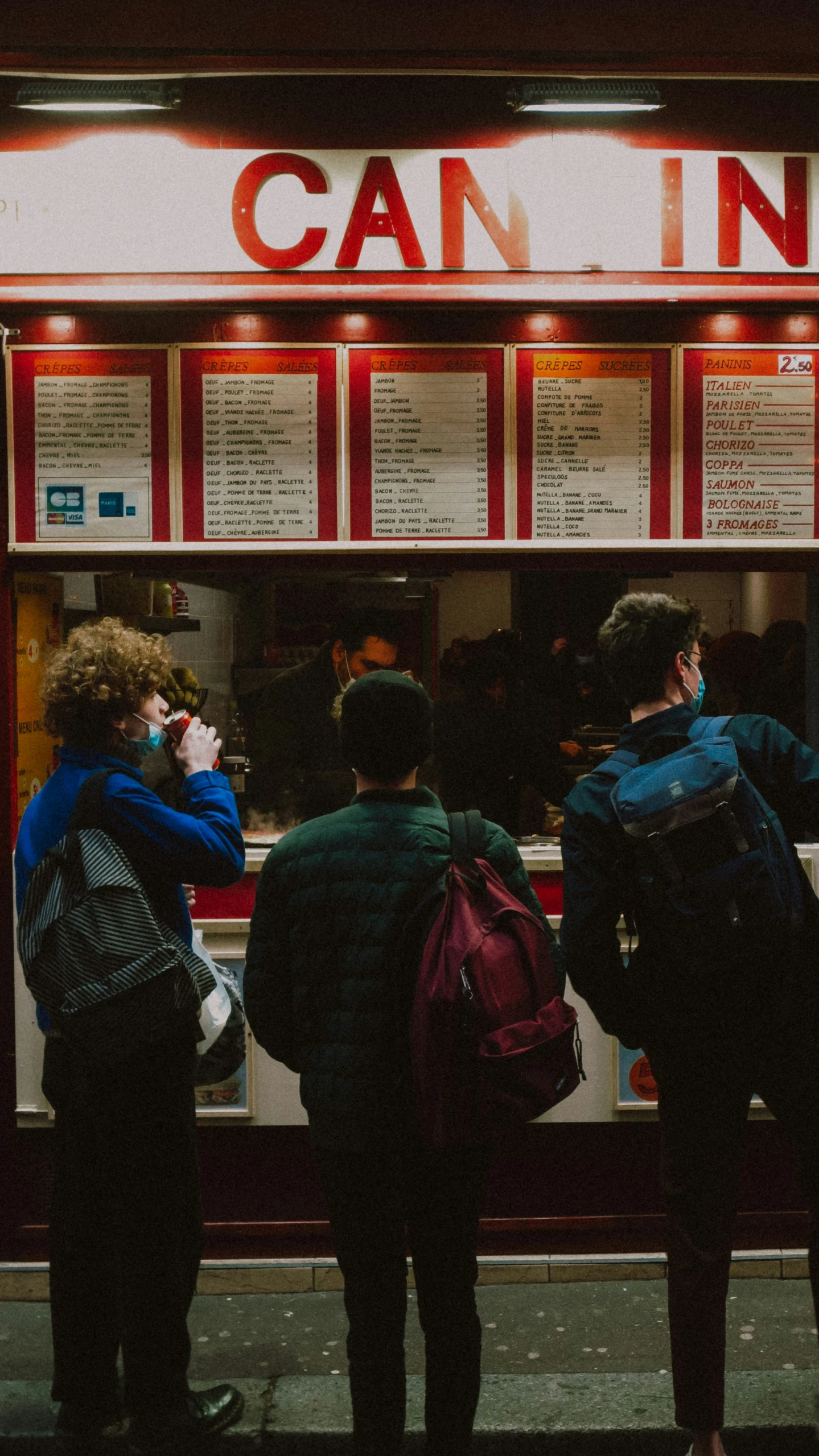 a group of people standing outside of a restaurant