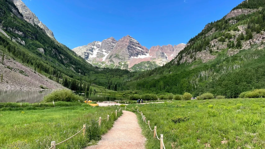 a pathway in a green field with a mountain view