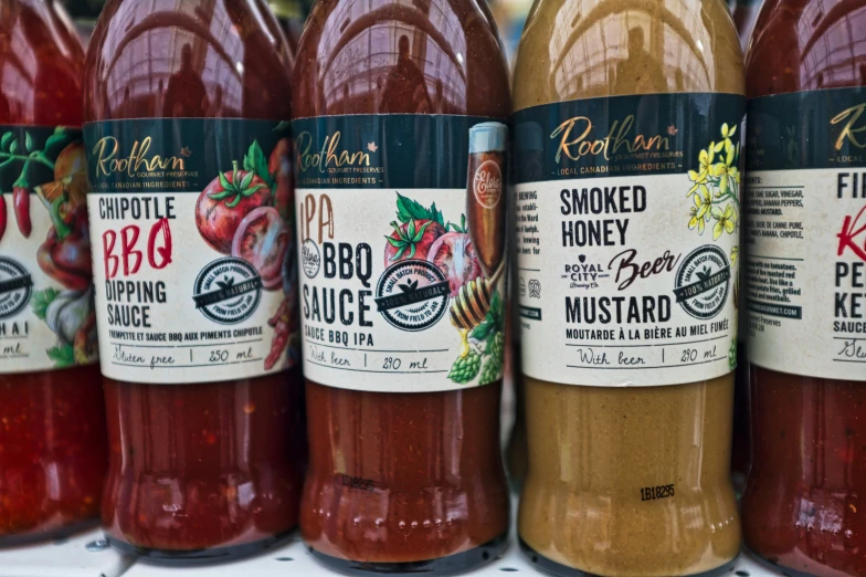 a variety of  sauces sitting in bottles together