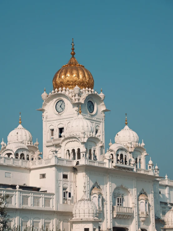 a white building with gold domes and a clock tower