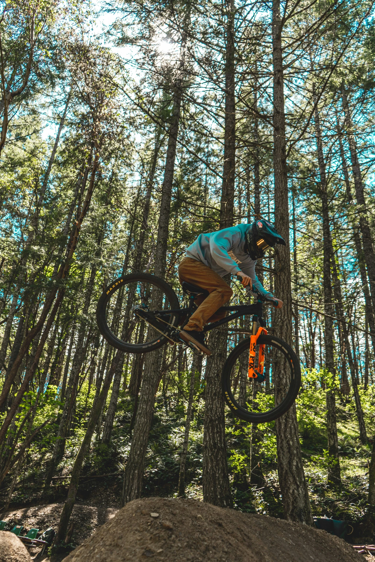 a mountain biker jumping a rocky hill in the woods