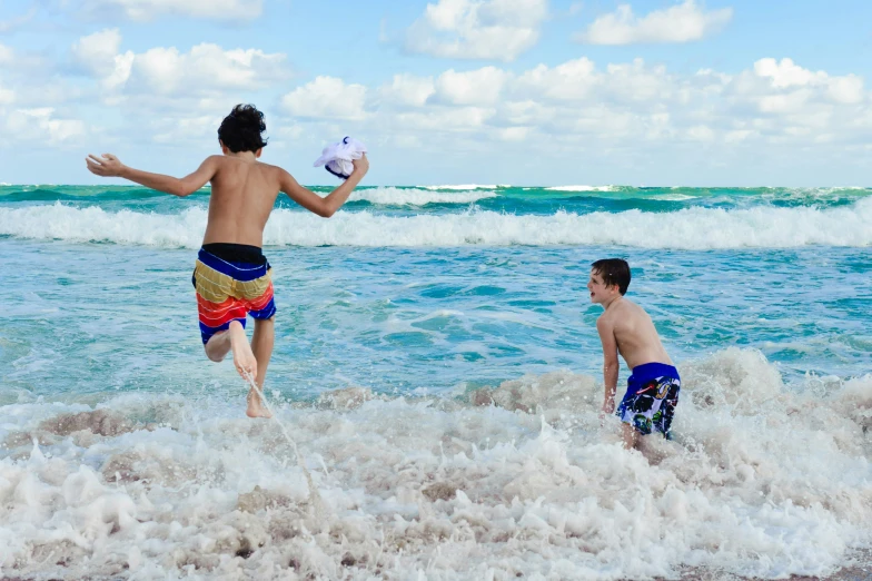 a boy and boy are playing in the ocean