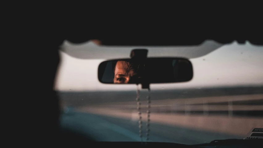 a man is reflected in the side view mirror