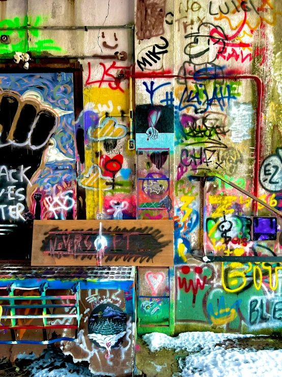 a graffiti covered wall next to the entrance of a building