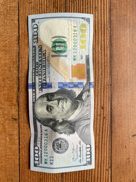 a one dollar bill on a piece of wood