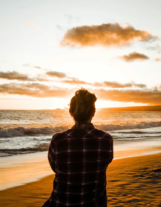 a person sitting on top of a sandy beach