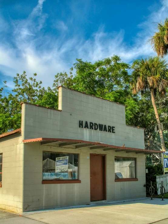 the front of an abandoned hardware shop with a sign on it