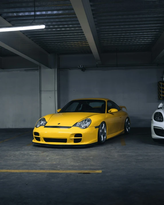 two different sports cars parked in an indoor area