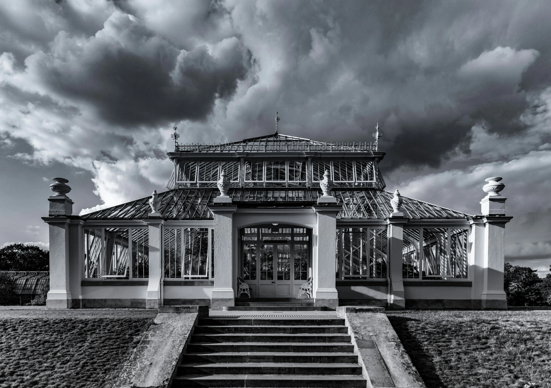 a black and white po of a building with a stormy sky in the background