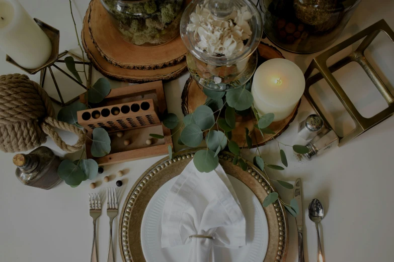 dinner table setting with center piece, silverware, and candles