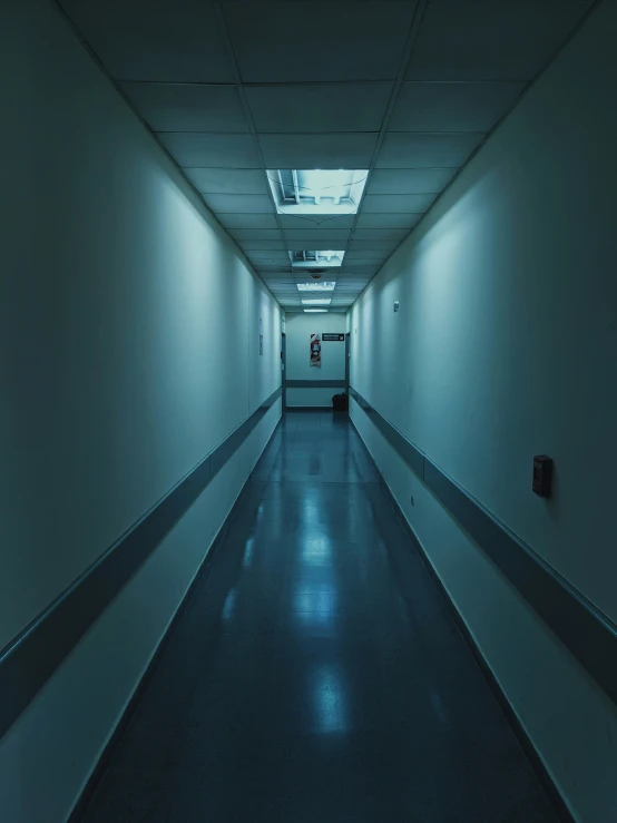 a long corridor with only one light visible on the ceiling