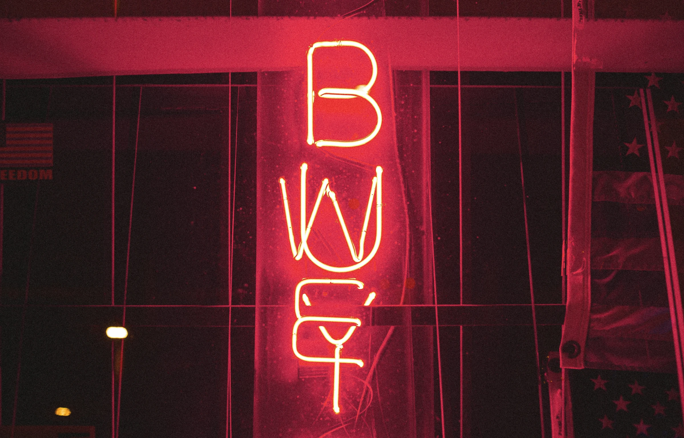 a neon sign hanging from the side of a building