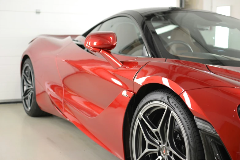 red sports car parked inside of a garage