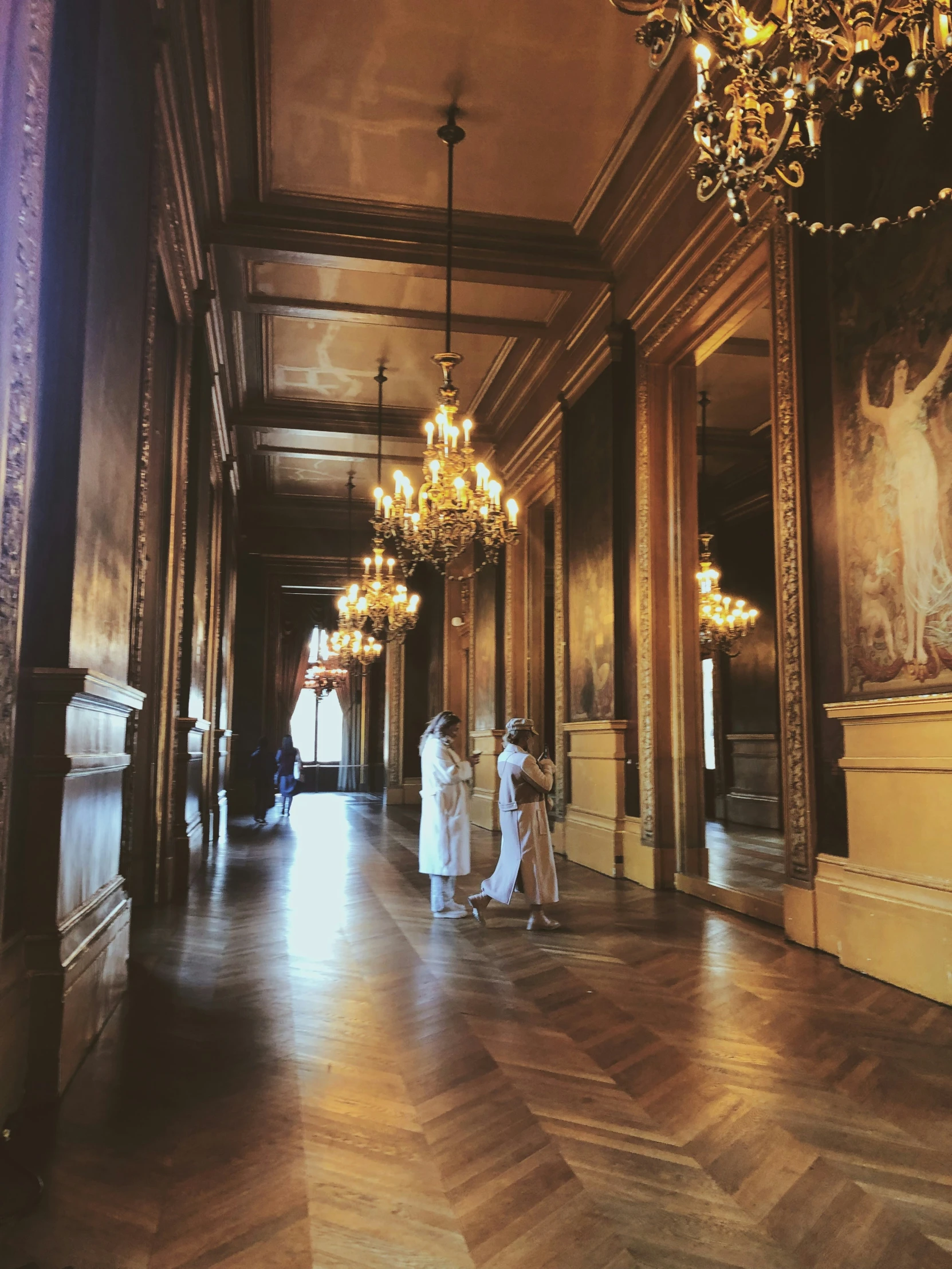 three women stand inside a large palace like building