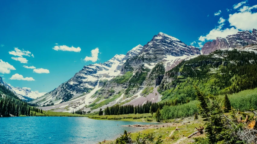 the snowy mountains are next to a river