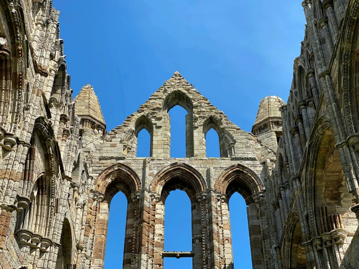 view from below of old ruin building with many large arches and high windows