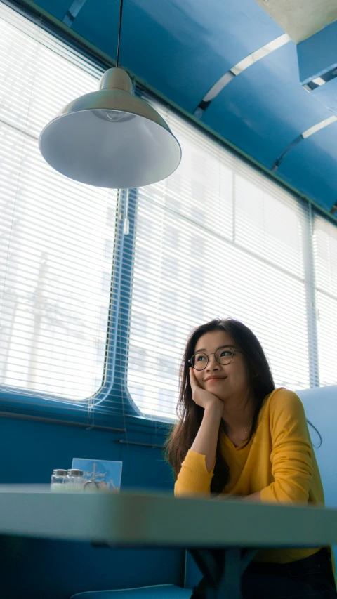 a woman sitting in a booth waiting for someone to pass by