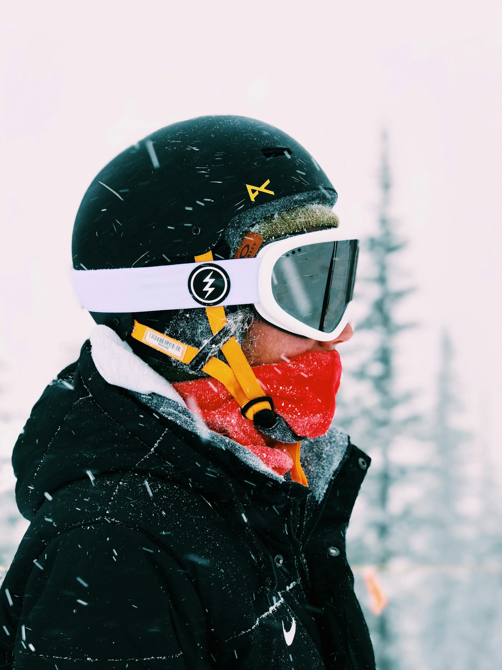 a person wearing a helmet and goggles with trees in the background