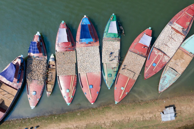 a number of small canoes at a dock near the water