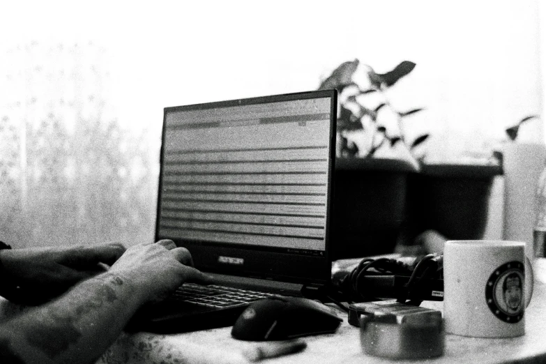 there is a man that is sitting at the desk with his laptop