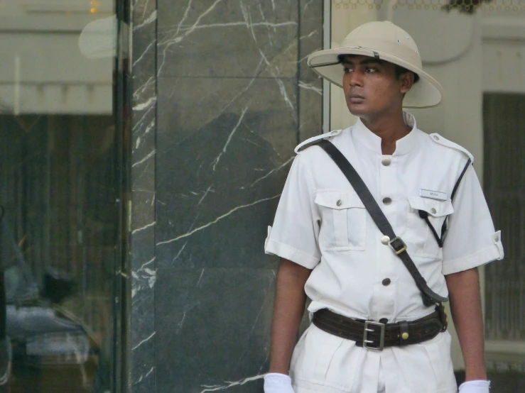 a young black man wearing a hat and uniform