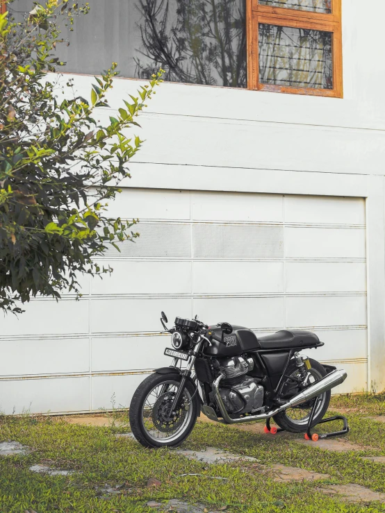 a black motorcycle sitting by a building with window