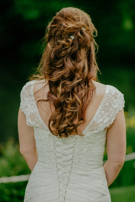 the back of a brides dress in front of a forest