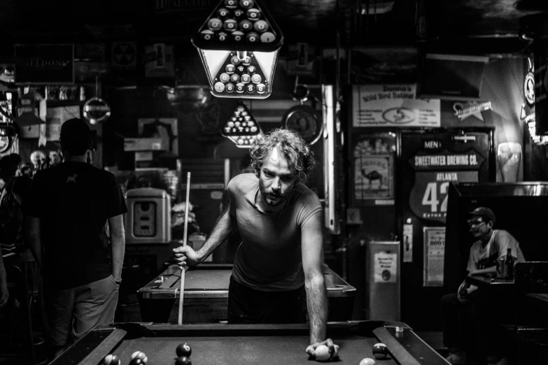 a man leaning on the back of a pool table