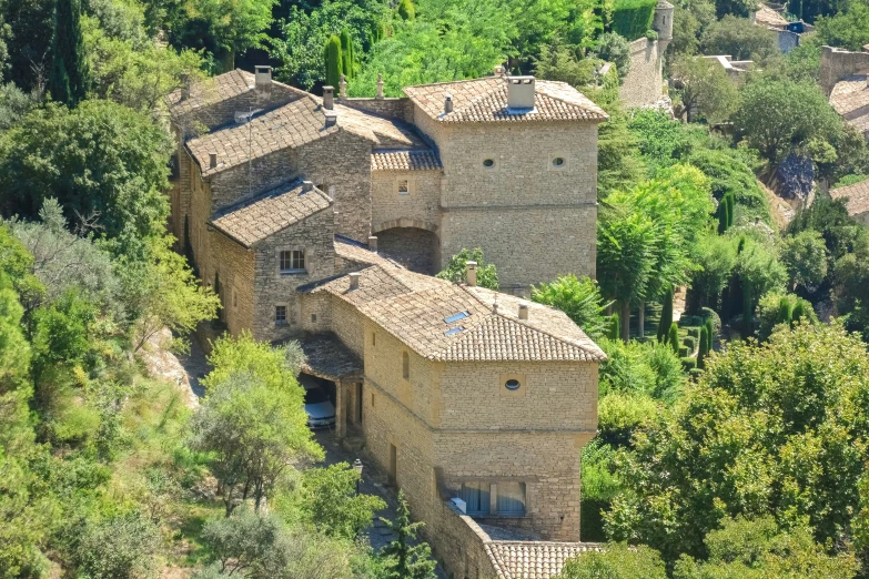 an old house with stone walls surrounded by trees