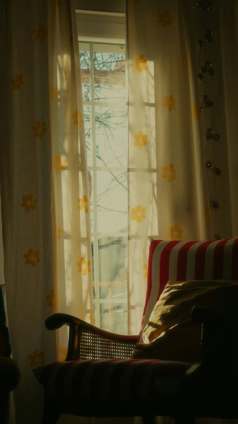 a striped chair is sitting in front of an open window