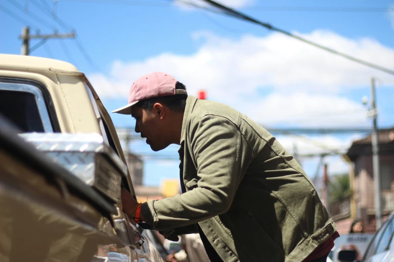 a man that is opening the side door of a car