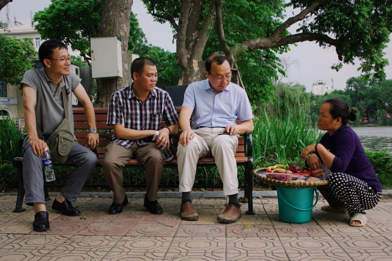 a group of three men sitting on top of a bench