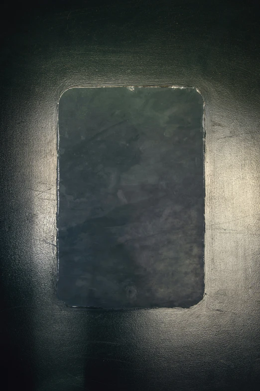 a square black paper with some brown writing on it