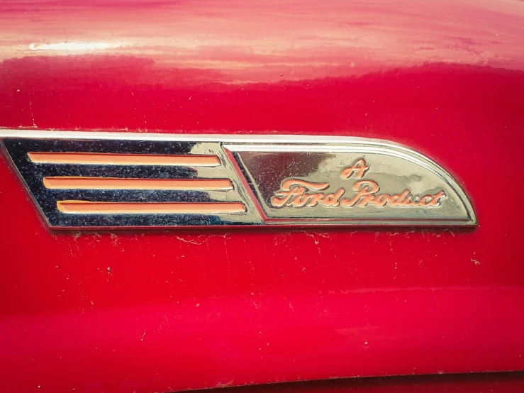 the emblem on a red antique automobile
