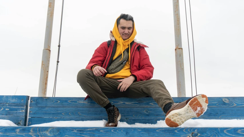 a man sitting on top of a blue bench